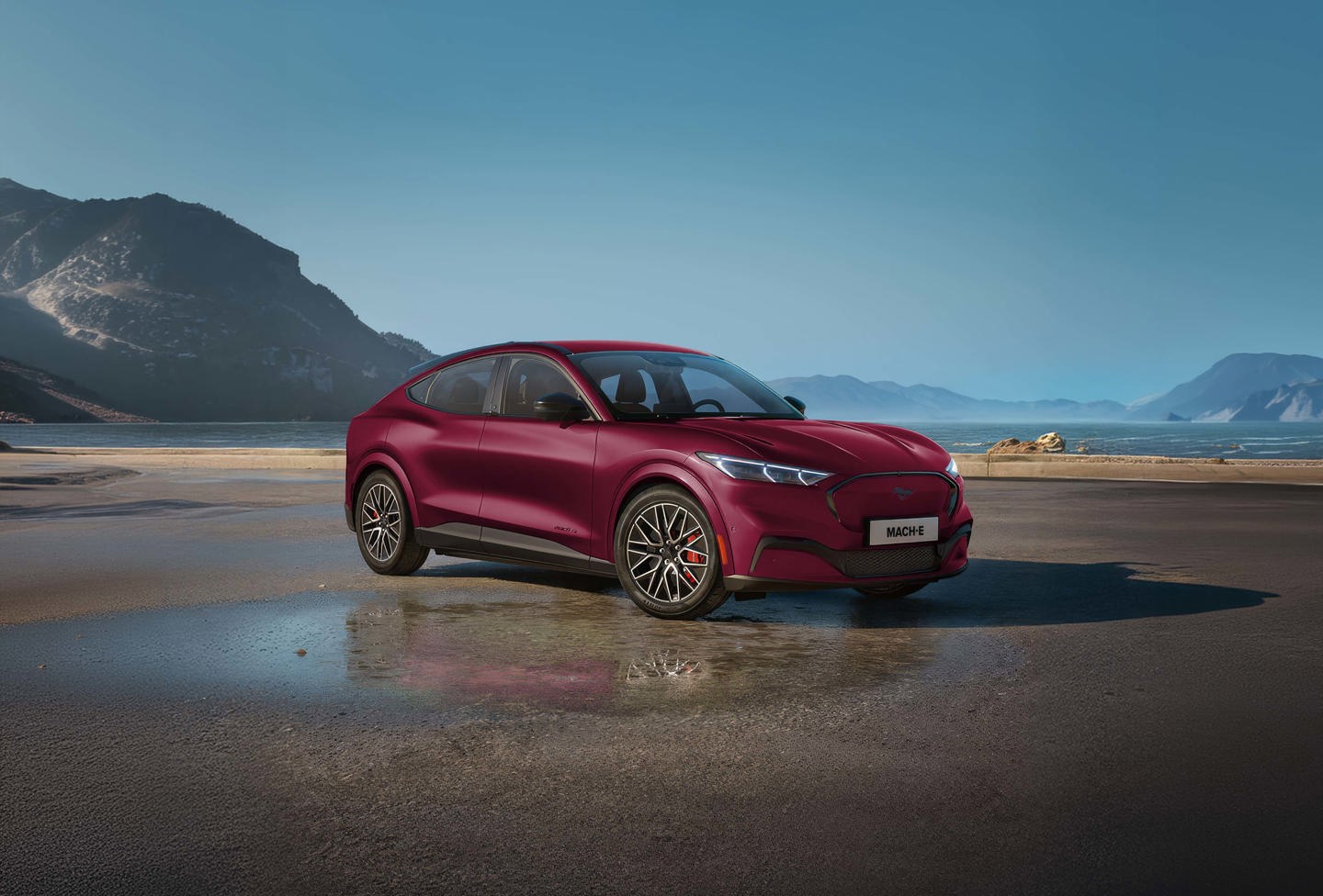 Tre SUV'er parkeret på en strand med bjerge og havet i baggrunden; billedet virker digitalt forvrænget.