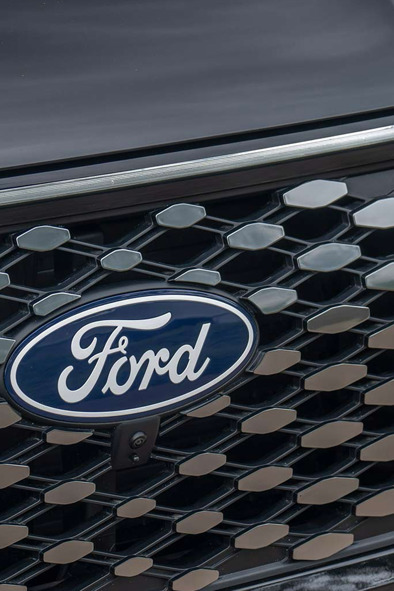 Nærbillede af en Ford-kølergrill med Ford-logoet og et sort bikagemønster.