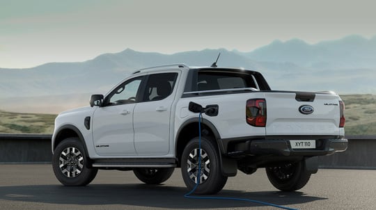 Hvid Ford Ranger Plug-in hybrid parkeret med ladekabel sat i