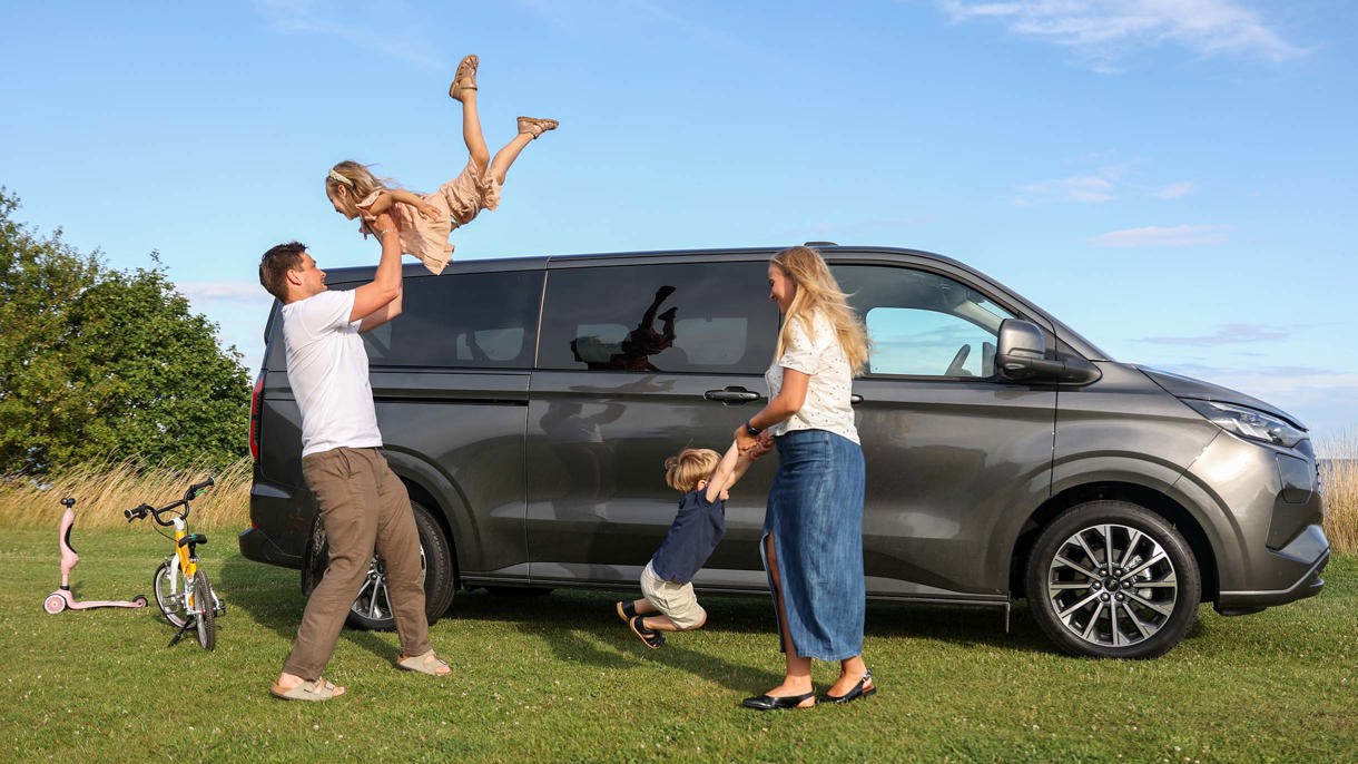 Familien Aarris leger ved siden af deres bil