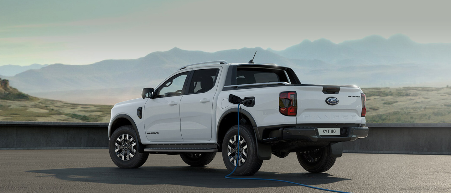 Hvid Ford Ranger Plug-in hybrid parkeret med ladekabel sat i