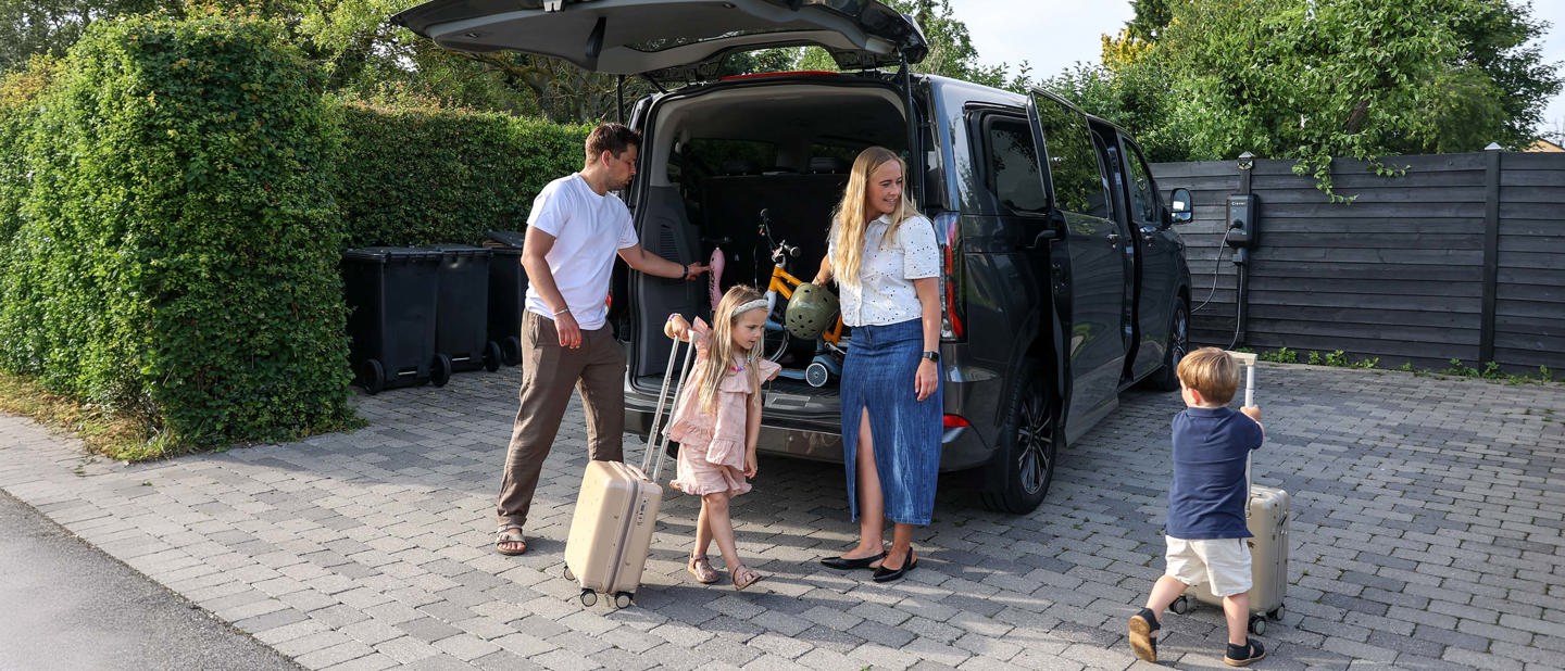 Familien Aarris står ved siden af deres bil