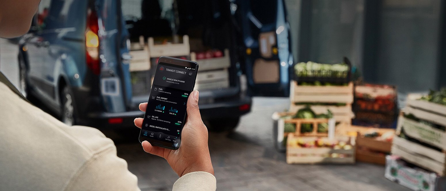 Kvinde kigger på mobil med Transit Connect oplysninger 