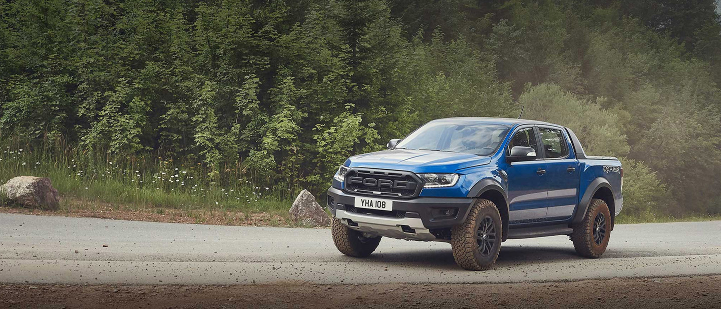 Ford Ranger Raptor opbygning på vej med grus. Grønt i baggrunden.