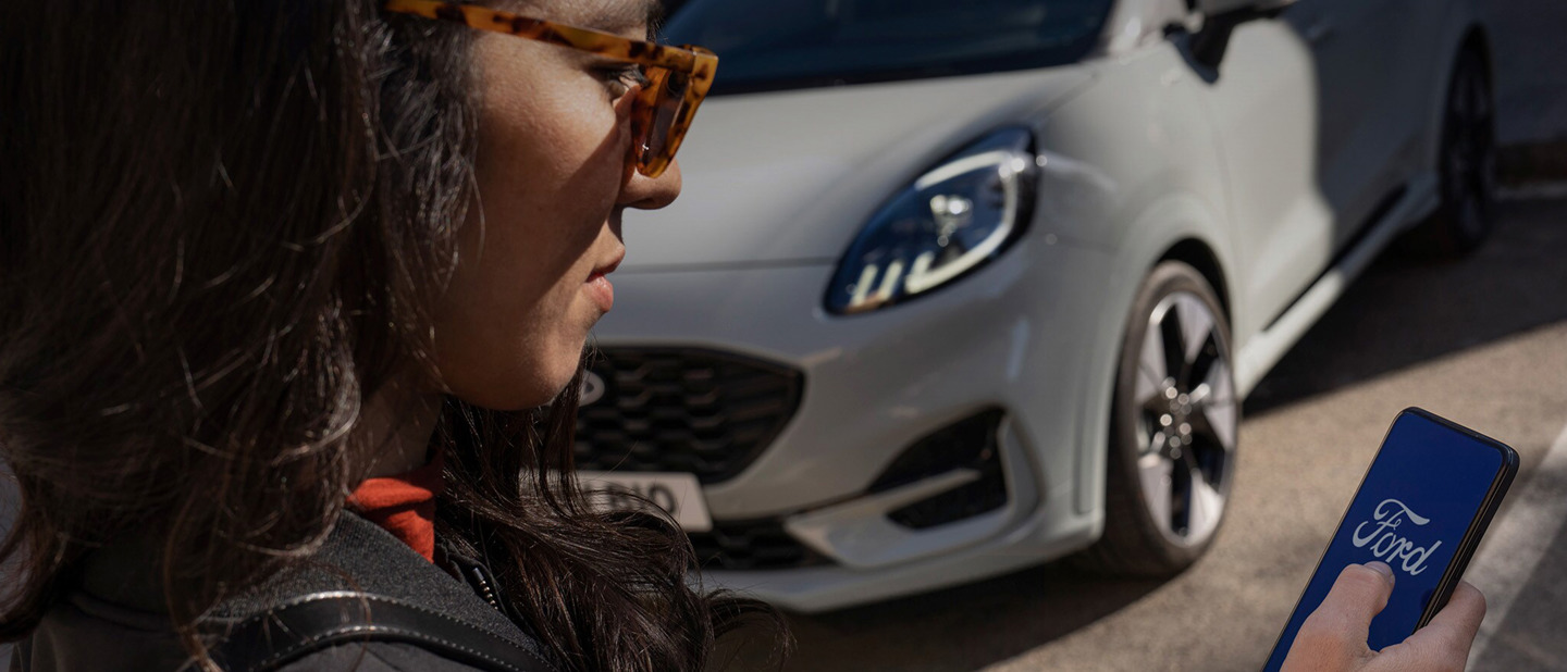 Kvinde er inde på Ford appen på sin mobil 