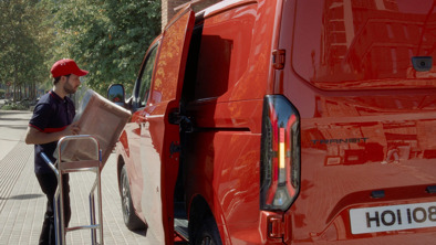 Mand ligger pakke i Transit Custom